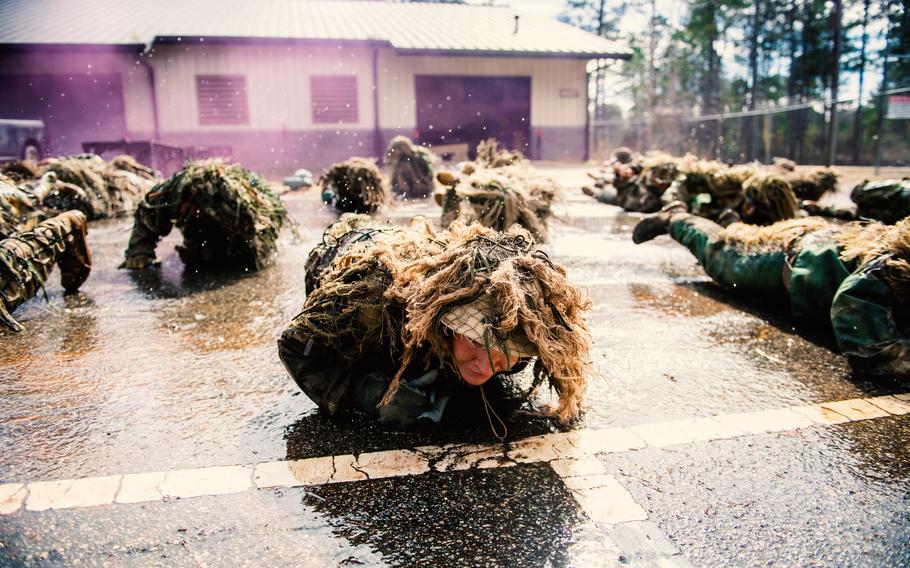 At U.S. Army Sniper School, 35 students participate in the ghillie wash, which tests durability and weathers their camouflage suits, at Ft. Benning, Ga., Feb. 5, 2021. A woman recently graduated for the first time from the seven-week sniper course, the Army announced.
