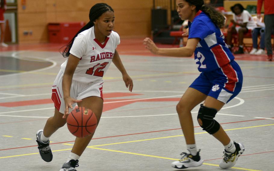 Kaiserslautern's Se'maiya Farrow, left, drives while Ramstein's Aliyah Jones defends at Kaiserlautern High School, Dec. 13, 2022.  The Royals won, 50-19.