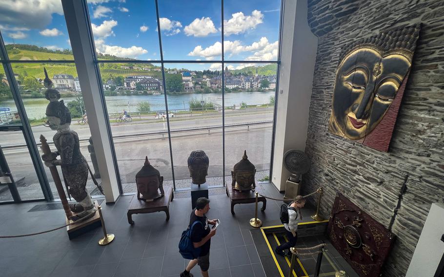 Visitors walk through the so-called glass room toward the basement exhibit hall at the Buddha Museum in Traben-Trarbach, Germany, June 11, 2022. The hall features a set of "Weekday Buddhas," representing the days of the week.