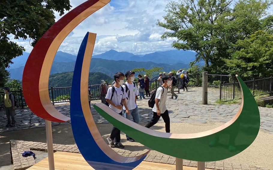Hikers pass the Paralympics logo on top of Mount Takao in western Tokyo, Saturday, Aug. 21, 2021. 