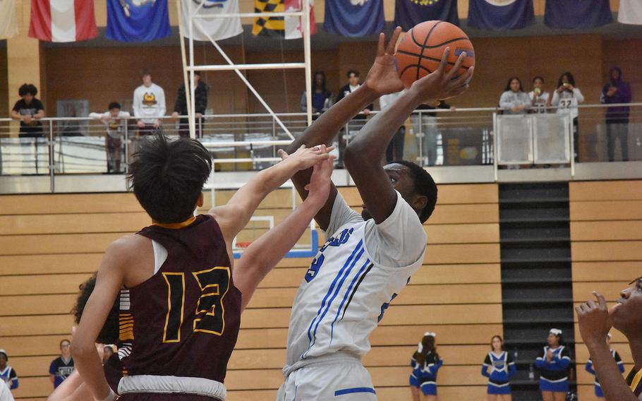 Hohenfels’ Jacob Idowu gets up a shot against Baumholder’s Wryson Catalan at the DODEA European Division III Basketball Championships at Wiesbaden, Germany, on Thursday, Feb. 15, 2024.