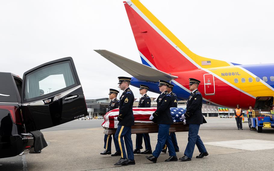 A casket being escorted onto a plane