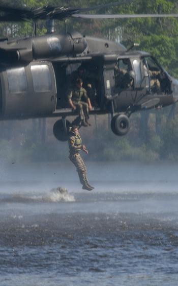 Army Capts. Chandler Ramirez and Logan Storie of the 7th Infantry Division jump out of a Black Hawk helicopter into Victory Pond during the final day of the Army’s annual Best Ranger Competition on Sunday, April 14, 2024, at Fort Moore, Ga. 