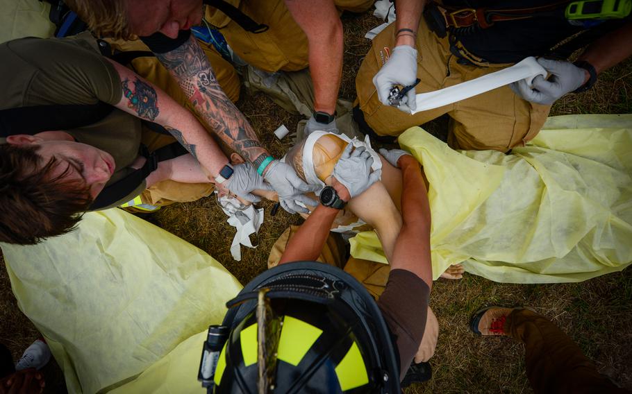 Firefighters assigned to the 86th Civil Engineer Group tend to a victim during a simulated aircraft crash scenario during Operation Varsity, an exercise testing basewide emergency response at Ramstein Air Base, Germany, July 26, 2022.