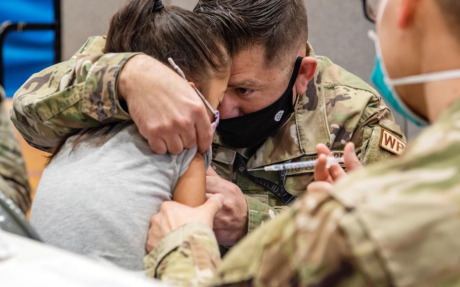 A parent comforts his child while she receives a pediatric vaccine at Kadena Air Base, Okinawa, Jan. 28, 2022. 