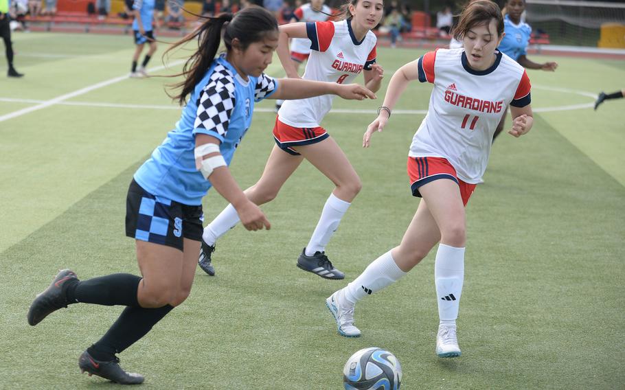Osan's Clarice Lee drives the ball upfield against Yongsan International-Seoul's Ellie Fertig and Maya Ben Ezra during Friday's Korea giirls soccer match. The Guardians won 2-1.