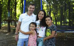 Volodymyr Zhdanov and his family pose in a park in Kyiv, Ukraine, Tuesday, Aug. 16, 2022. It was early one morning when life under Russian occupation became too much for Volodymyr Zhdanov: Rocket fire aimed at Ukrainian forces struck near his home in the city of Kherson, terrifying his young children. (AP Photo/Roman Hrytsyna)