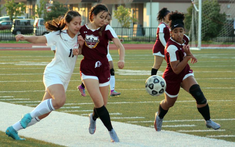 E.J. King's Maliwan Schinker and Matthew C. Perry's Haleigh Quinn and Ivanelis Nieves-Bermudez chase the ball during Friday's DODEA-Japan girls soccer match. The Samurai won 1-0, their first win over the Cobras this season.