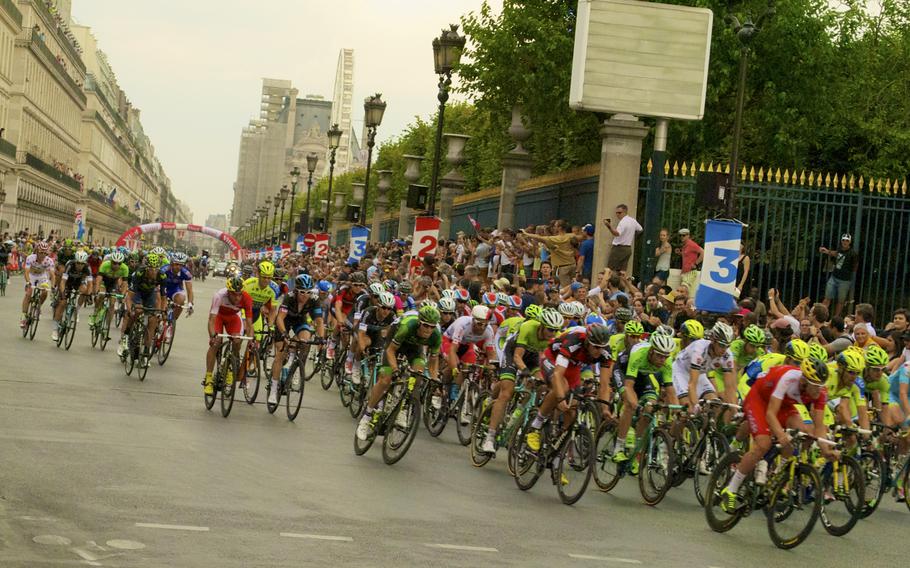 The Tour de France peloton races down the Champs-Élysées in Paris en route to the finish line.