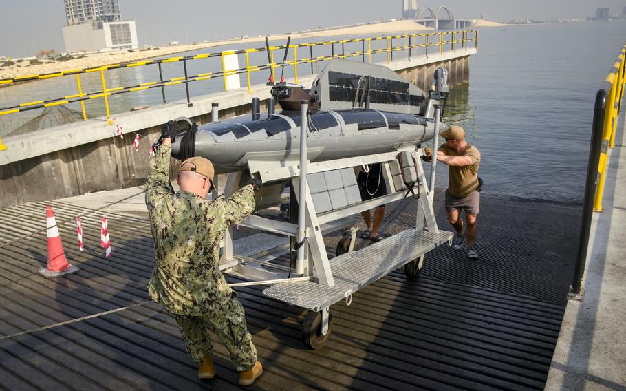 Sailors with the Navy’s Task Force 59 launch a drone boat from a pier at Naval Support Activity Bahrain, Dec. 1, 2022, as part of the Digital Horizon exercise. The unmanned vessel, the Ocean Aero triton, carries sensors that can conduct surveillance. It also can transform between surface and submarine modes. 