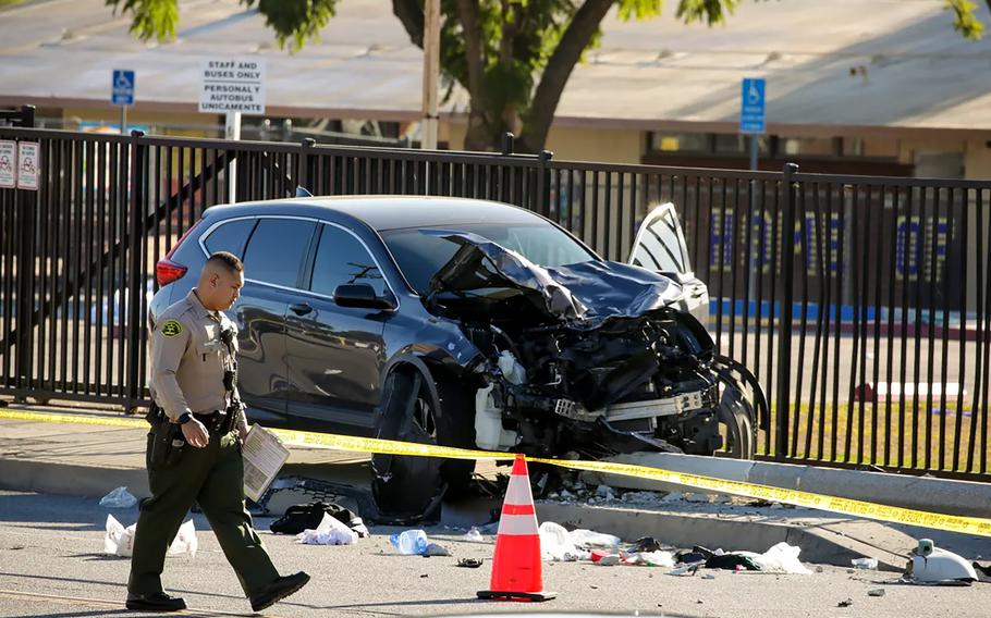 An SUV that struck Los Angeles County sheriff’s cadets during a morning run Wednesday, Nov. 16, 2022, rests at the base of a toppled light pole in Whittier, Calif.