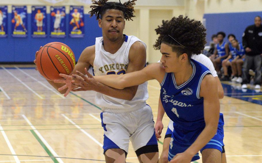 Tournament MVP Marcus Woods of Yokota and Osan's Travus Boyd scuffle for the ball during Wednesday's boys D-II final.