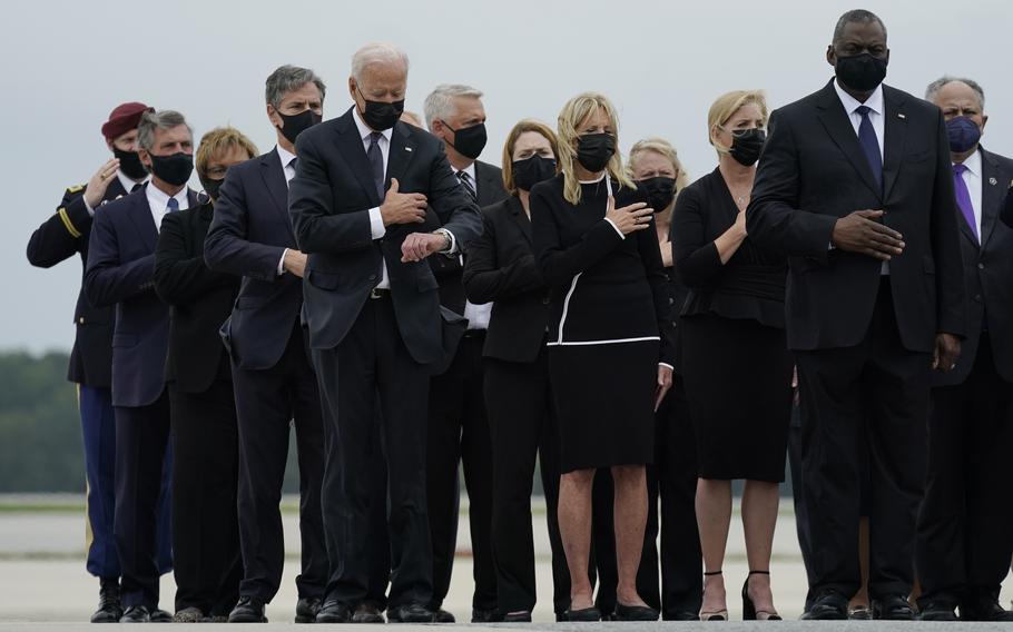 President Joe Biden, first lady Jill Biden and others attend a casualty return as a carry team finishes placing the transfer case containing the remains of Marine Corps Lance Cpl. Jared M. Schmitz, 20, of St. Charles, Mo., into a transfer vehicle on Aug. 29, 2021, at Dover Air Force Base, Del.