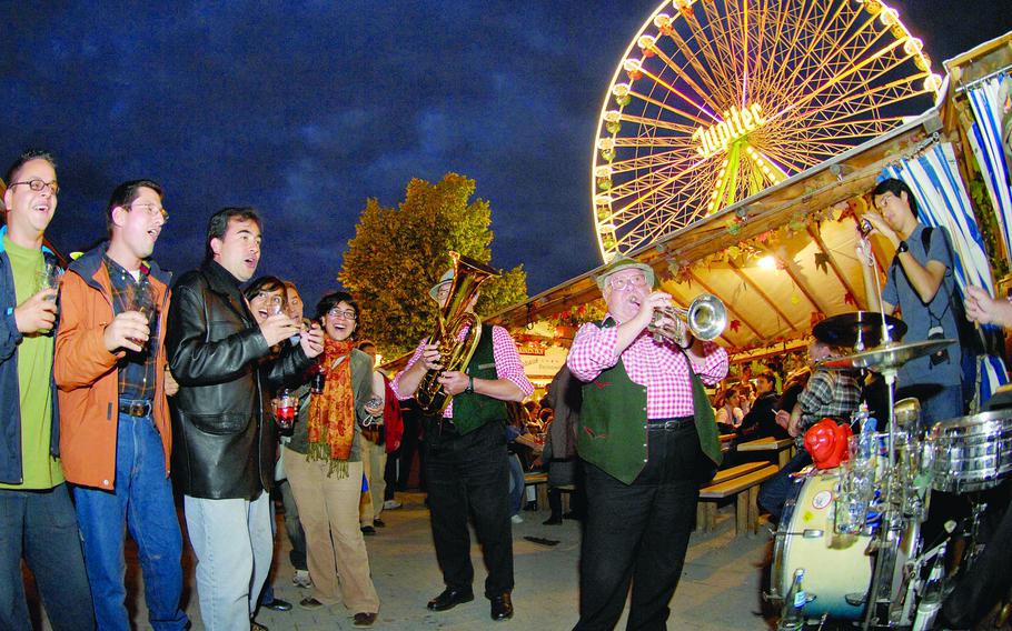 Visitors to Germany's Wurstmarkt festival in Bad Duerkheim sing along with a traditional oompah band. The Wurstmarkt, which the organizers say is the largest wine festival in the world, has been canceled for the second straight year because of the coronavirus pandemic.