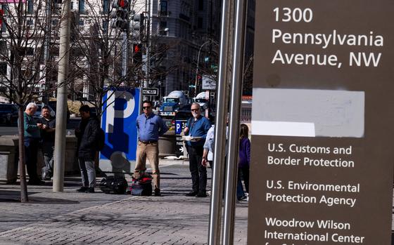 Workers at the Ronald Reagan building in downtown Washington wait for a bus.