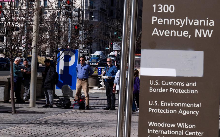 Workers at the Ronald Reagan building in downtown Washington wait for a bus.