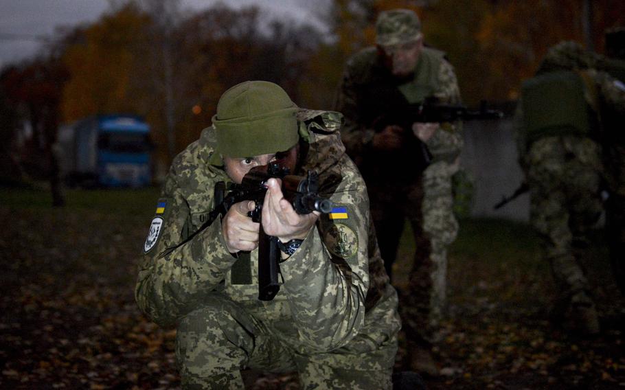 A Ukrainian soldier moves with his squad under simulated fire to retrieve a casualty during training at a site on the outskirts of Kyiv, on Oct. 27, 2022.