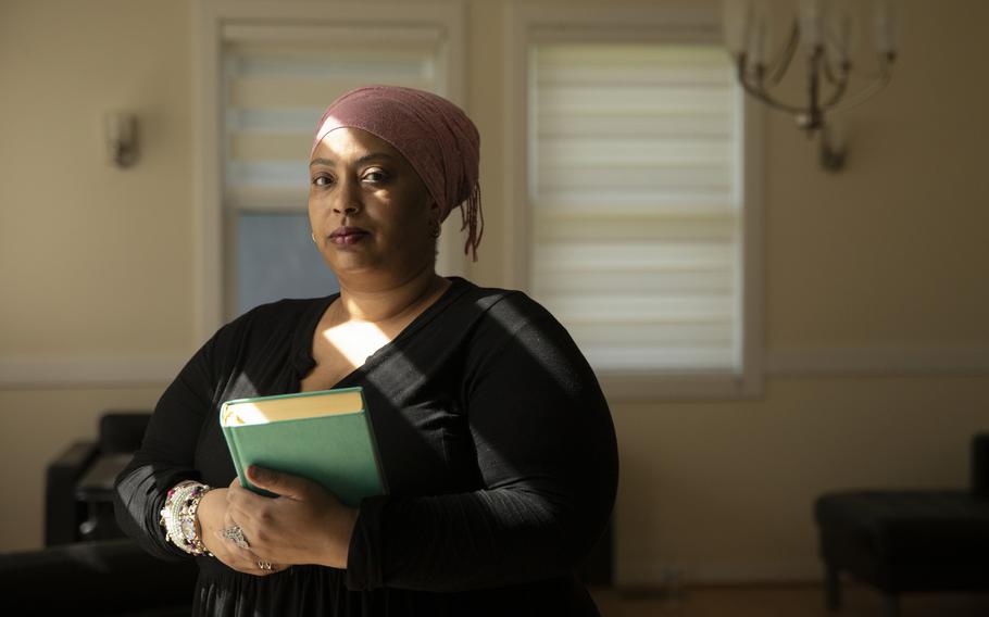 Karen Kaiser holds a Quran at her home in Lanham, Md., on July 20, 2022. She said the Quran has helped her through her disabilities and her experience with abortion. 