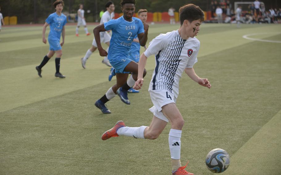 Yongsan International-Seoul's Luc Mercier drives the ball upfield against Osan's Justiss Parker-Jones during Friday's Korea boys soccer match. The Guardians won 5-1.