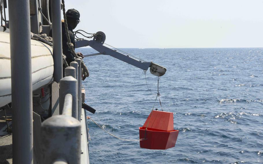 Lt. Cmdr. Dre Johnson of the Navy's Task Force 59 watches as a live-fire target is lowered into the water from the USS Dextrous during exercise Digital Talon in the Persian Gulf on Oct. 23, 2023.