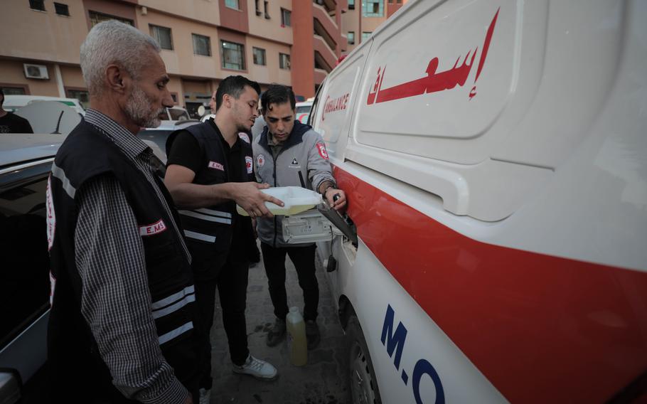Paramedics attempt to fill up the fuel tank of their ambulance with petroleum jelly used for first aid at the Nasser Medical Hospital in Khan Younis in the southern Gaza Strip on Oct. 17, 2023. 