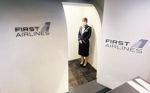 A flight attendant greets guests as they board a First Airlines "flight" in Tokyo, March 3, 2024.