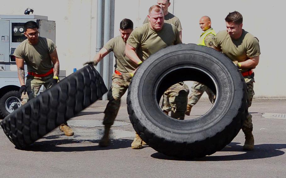 The Raven's Fury team, part of the 726th Air Mobility Squadron out of Spangdahlem Air Base, does the tire flip event during the endurance exercise of the 721st Aerial Port Squadron Multi-Capable Airmen Rodeo at Ramstein Air Base, July 23, 2021. The tire on the left was filled with water to add to the difficulty.