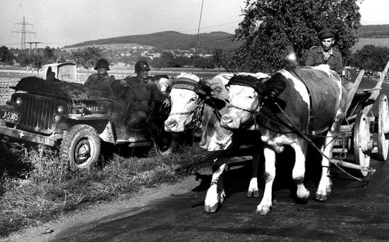 West Germany, October, 1951: A farmer with an ox-drawn cart passes a jeep parked in the shade of a tree during Exercise Combine in the Rhine Valley.

Looking for Stars and Stripes’ historic coverage? Subscribe to Stars and Stripes’ historic newspaper archive! We have digitized our 1948-1999 European and Pacific editions, as well as several of our WWII editions and made them available online through https://starsandstripes.newspaperarchive.com/

META TAGS: military life; cold war; agriculture; Germany