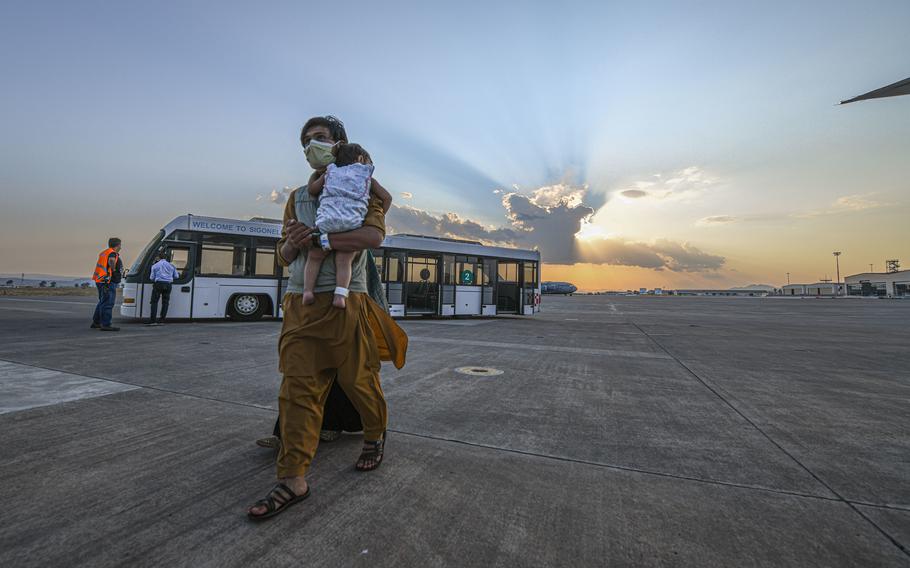 Evacuees from Afghanistan board a Boeing 777 bound for the United States from Naval Air Station Sigonella, Italy, Aug. 28, 2021. 