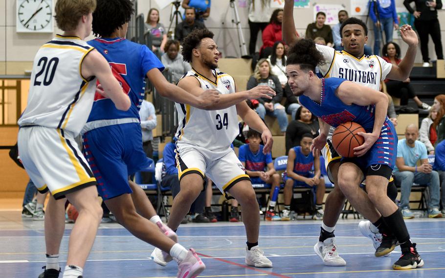 Ramstein’s Israel Rouse drives to the basket as Stuttgart’s Trenton Jackson, center, and Alex Guthrie, right, defend during pool play of the Division I DODEA European Basketball Championships at Ramstein High School on Ramstein Air Base, Germany.