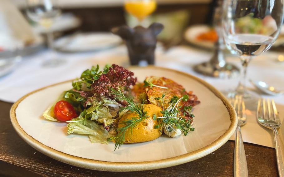 A serving of vegan Nicolachs, smoked carrot slices loosely inspired by the flavors of smoked salmon, is served with crispy potato pancakes and a creamy, nondairy spiced mustard crème and side salad at Hotel Nicolay 1881, in Zeltingen-Rachtig, Germany, March 2, 2022.