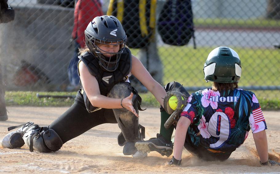 Kubasaki's Addi LaTour slides home safely past the tag of Kadena catcher Emaleigh Appleton during Tuesday's Okinawa softball game. The Dragons won 8-7.