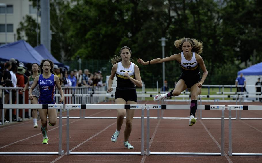 Marnessa Rea of Stuttgart clears a hurdle during the girls 300-meter hurdles at the 2024 DODEA European Championships at Kaiserslautern High School in Kaiserslautern, Germany, on May 24, 2024, followed by teammate Madeleine Alberico and Ramstein’s Madeline Moga.