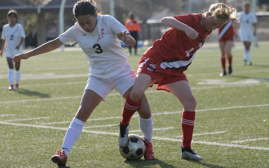 E.J. King's Alyssa Garcia and Nile C. Kinnick's Ainsley Rochholz tangle for the ball during Friday's All-DODEA-Japan soccer tournament quarterfinal. The Red Devils won 3-1.
