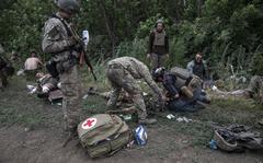 Wounded Ukrainian soldiers are treated outside the embattled city of Lysychansk, Ukraine, on June 26, 2022. 