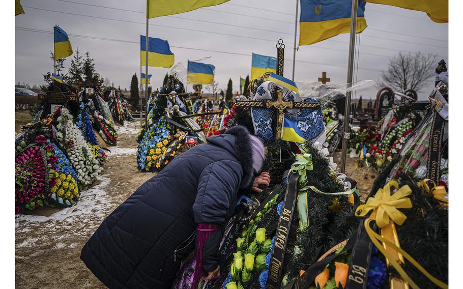 Mariia Kurbet reacts next to the grave of her son Vasyl Kurbet, a Ukrainian serviceman killed in Bakhmut, at a cemetery in Bucha, near Kyiv on Feb. 24, 2023, on the first anniversary of the Russian invasion of Ukraine. 