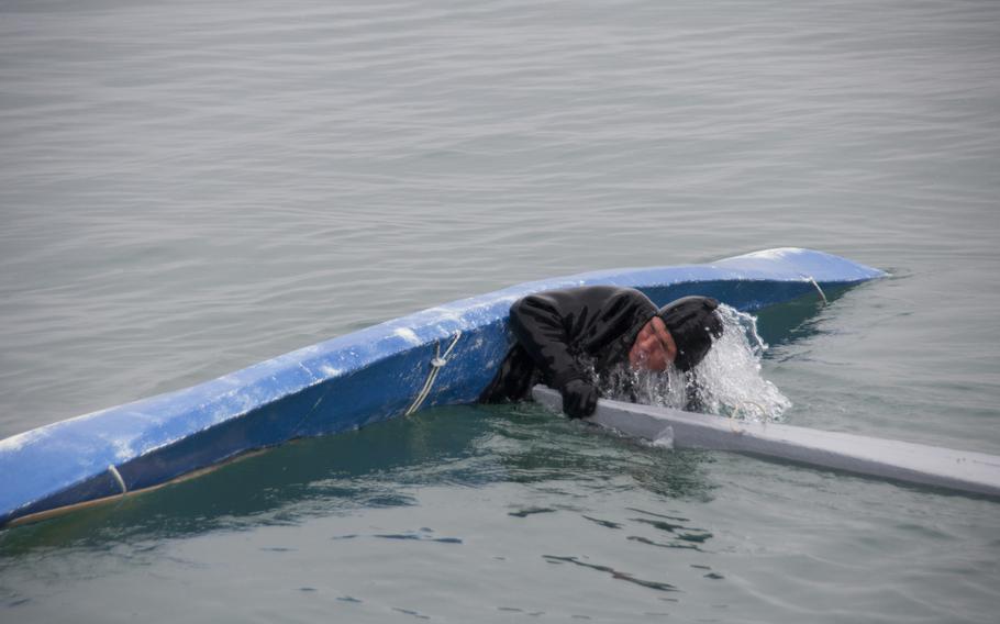 Malik Kleist rights his kayak with the help of his fellow kayaker, Outdlaq Qujaukitsoq. A group of Inuit locals demonstrated local culture and provided food in front of a small but appreciative and apprehensive crowd watching from the Thule Air Base main pier.