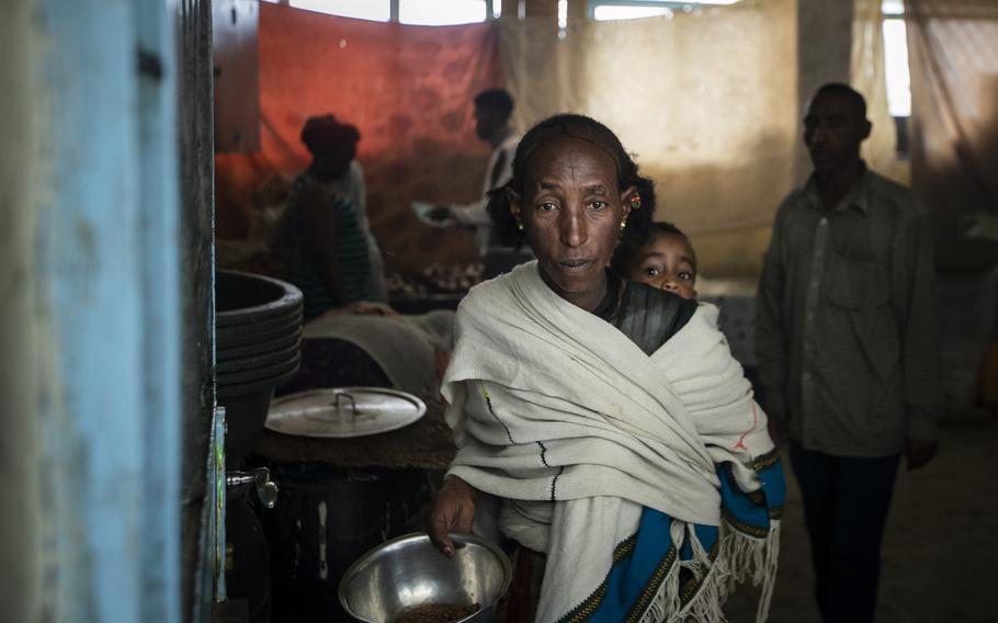 A displaced Tigrayan woman walks out of a classroom-turned-kitchen after receiving food at the Hadnet General Secondary School which has become a makeshift home to thousands displaced by the conflict, in Mekele, in the Tigray region of northern Ethiopia on May 5, 2021.