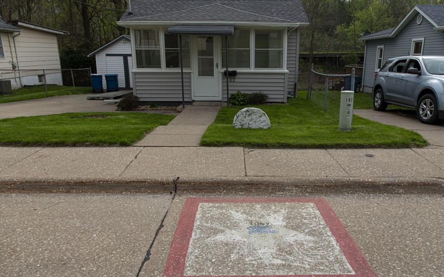 Faded painted stars mark the homes of the eight residents who died serving in World War II and the Korean War along Hero Street in Silvis, Ill.