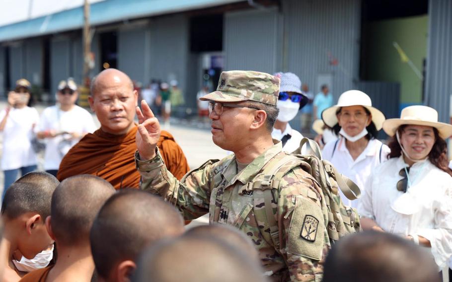 U.S. Army Chaplain (Capt.) Songkran Waiyaka shows the chin mudra, a Buddhist hand gesture, to novice monks at the port in Sattahip, Thailand, during exercise Cobra Gold.