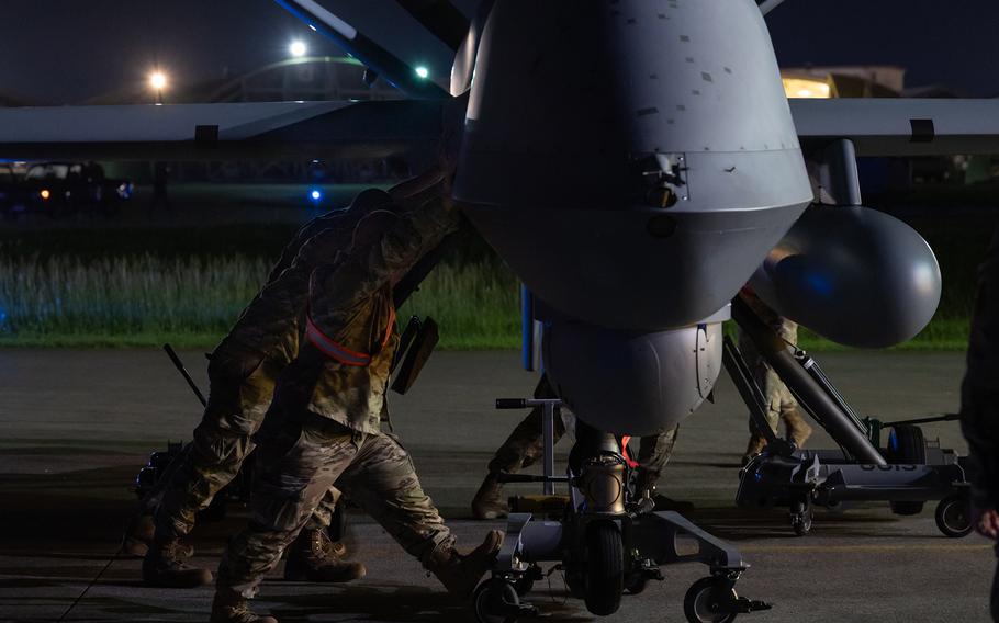 Maintenance personnel push an MQ-9 Reaper into an aircraft shelter at Kadena Air Base, Okinawa, Oct. 13, 2023.