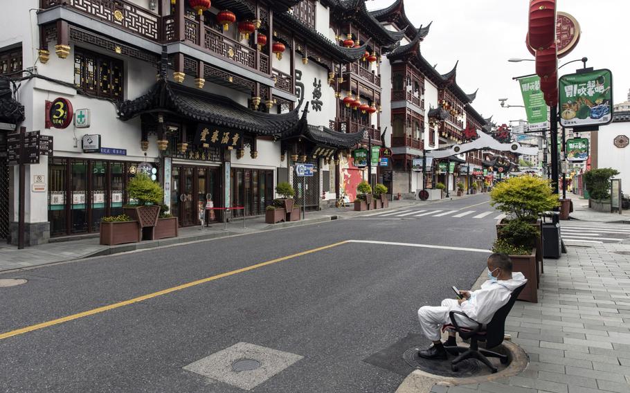 A worker sits along a near-empty road during a lockdown due to COVID-19 in Shanghai on May 16, 2022.