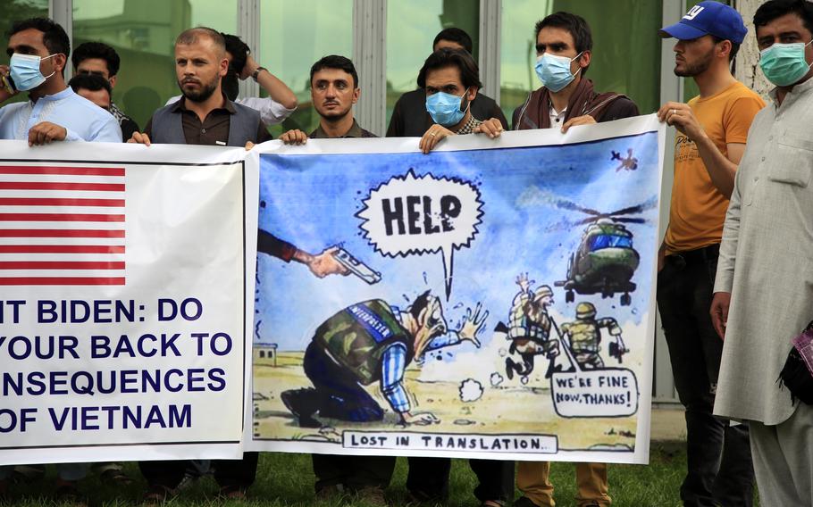 In this Friday, April 30, 2021, file photo former Afghan interpreters hold banners during a protest against the U.S. government and NATO in Kabul, Afghanistan.