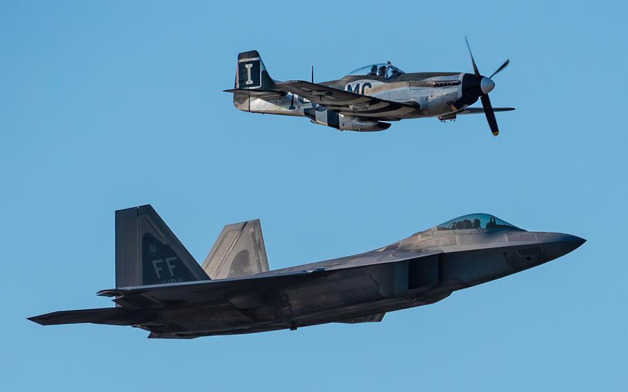 A heritage flight consisting of a World War II-era P-51D Mustang and a modern U.S. Air Force F-22 Raptor performs an aerial demonstration over the Ohio River in downtown Louisville, Ky., April 23, 2022, as part of the Thunder Over Louisville air show. Thunder Over Louisville will light up the Louisville skyline for its 34th year. The daylong event is set for Saturday, April 22, 2023, on the Waterfront.