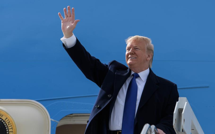 President Donald Trump smiles and waves.