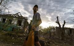 A person walks past the damaged homes from a rocket attack early this morning, Tuesday, Aug. 16, 2022, in Kramatorsk, eastern Ukraine, as Russian shelling continued to hit towns and villages in Donetsk province, regional officials said. (AP Photo/David Goldman)