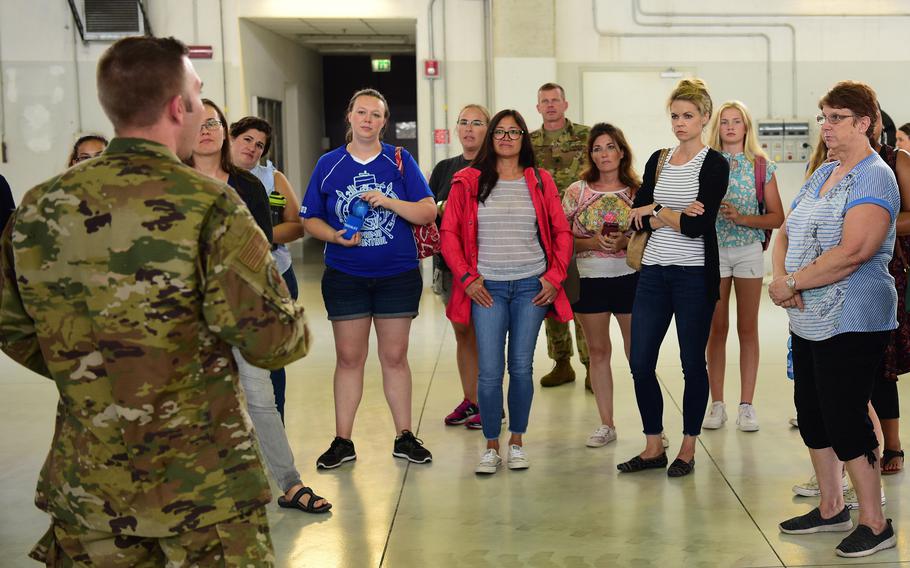 Spouses and family members from the 606th Air Control Squadron listen to a brief during a spouse day in 2019, at Aviano Air Base, Italy.