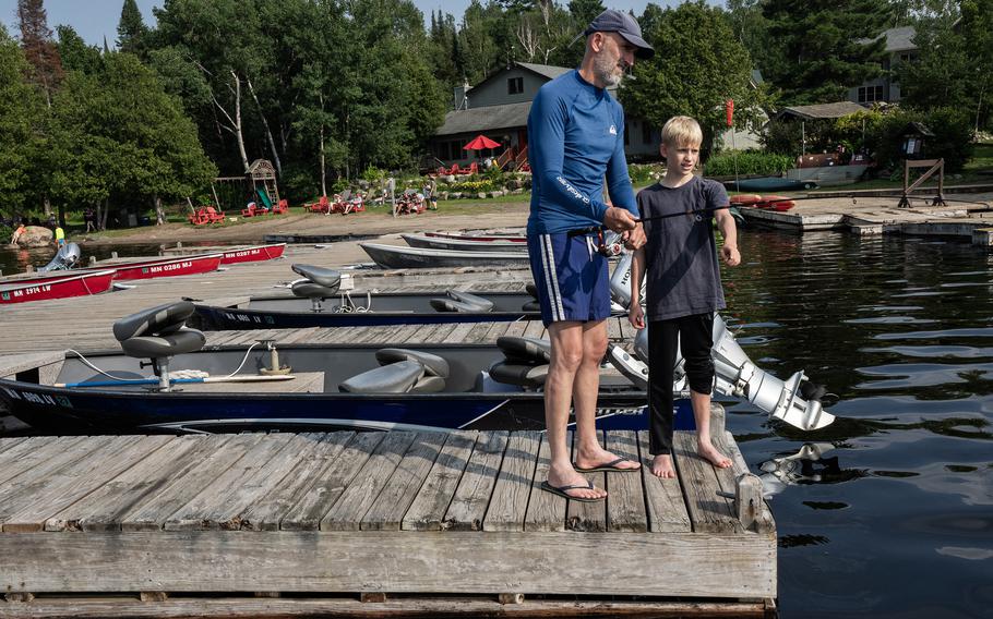A man and boy fish off a dock in Grand Marais, Minn. 