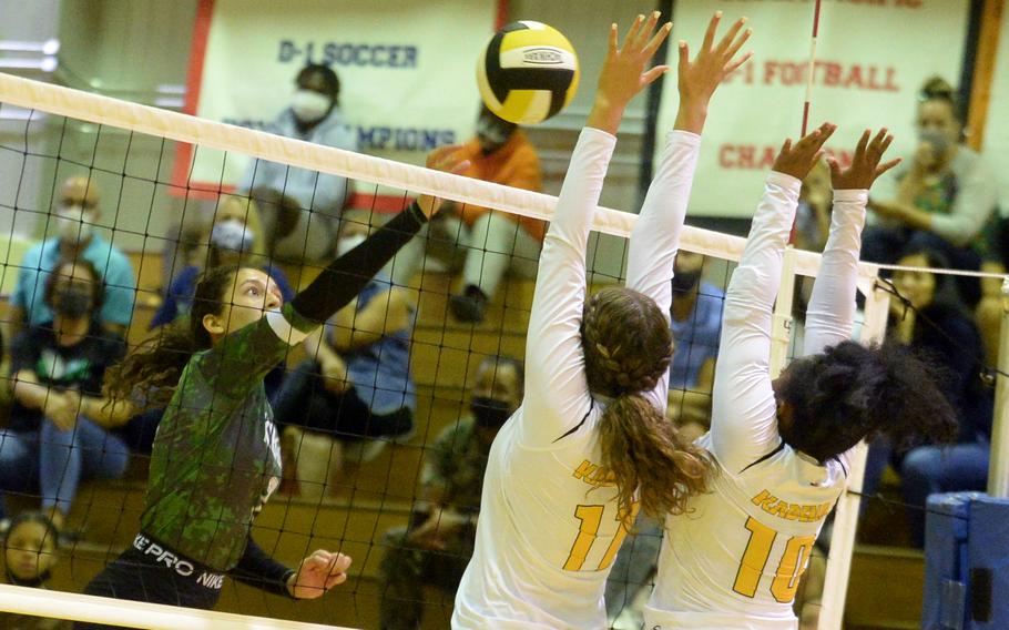 Kubasaki’s Sophia Grubbs spikes through the double block of Kadena’s Presley Pearce and Kaya Castle during Tuesday’s Okinawa girls volleyball regular-season finale. 