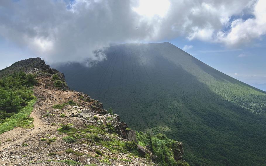 Morning clouds cling to the summit of Mount Asama, Japan, viewed from Mount Jakotsu on July 29, 2023.